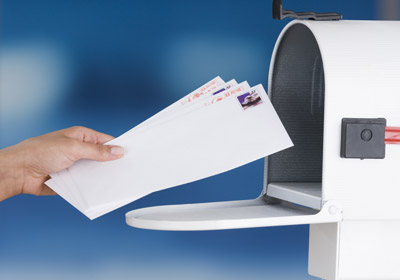 Envelopes Being Deposited Into Mailbox