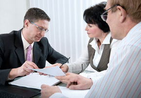 Couple Discussing Document with Businessman Couple Discussing Document with Businessman