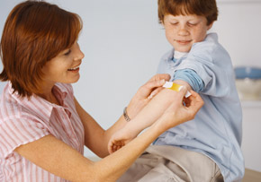 Mother Putting Bandage on Son Mother Putting Bandage on Son