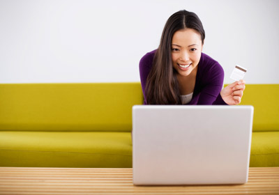 Happy Woman with Credit Card at a Laptop Happy Woman with Credit Card at a Laptop